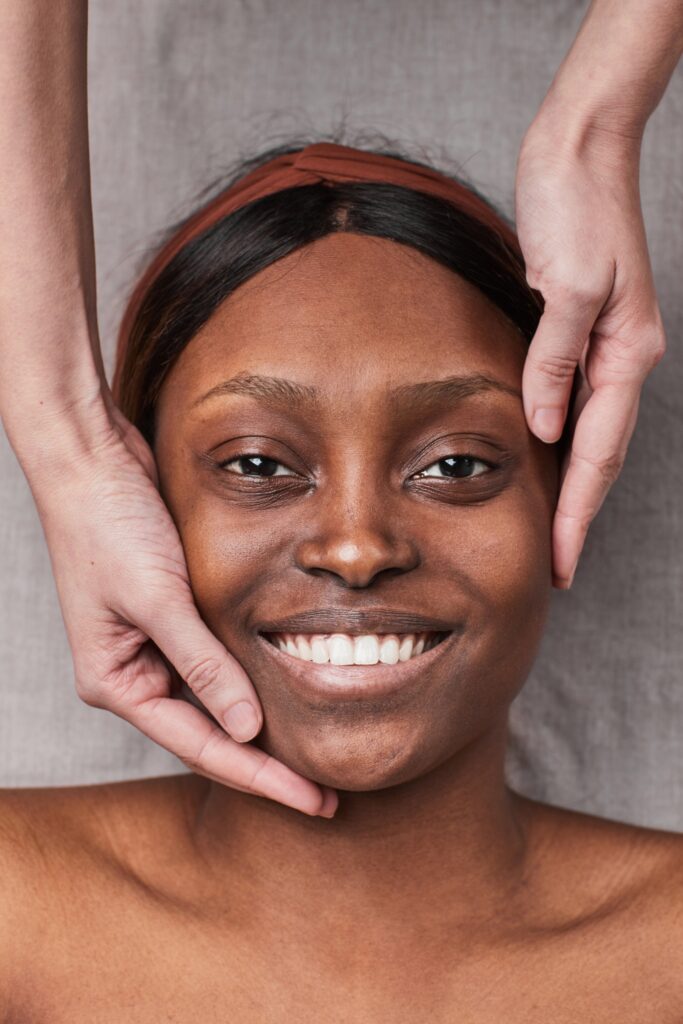 Image Of Smiling Woman Receiving A Facial Massage.